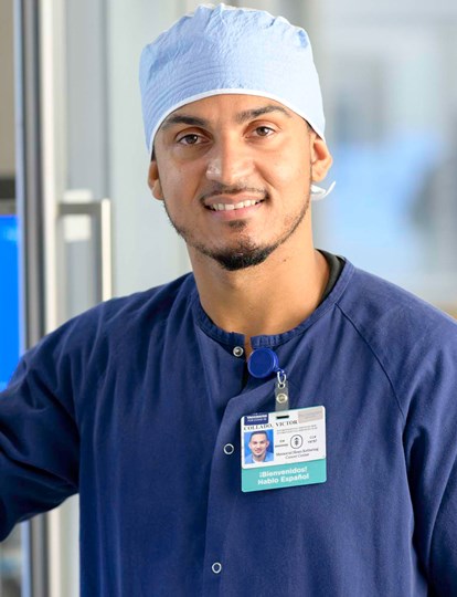 Medical Colleague Leaning Against Glass Door And Smiling