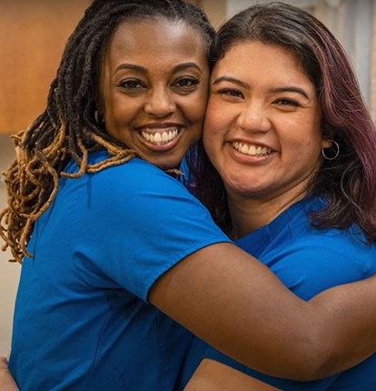 Two Nurses Hugging And Smiling