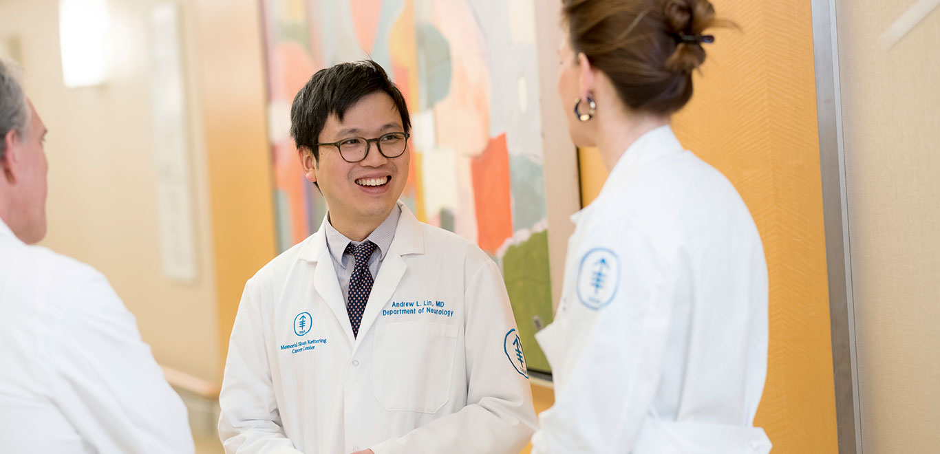 Three MSK Colleagues in lab coats smiling and chatting