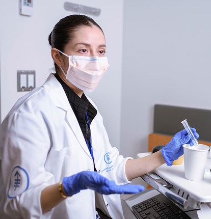 MSK Colleague in lab coat sitting at a desk talking to a patient