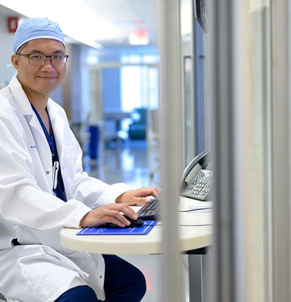Image Of Wenhui Chen Sat At Computer